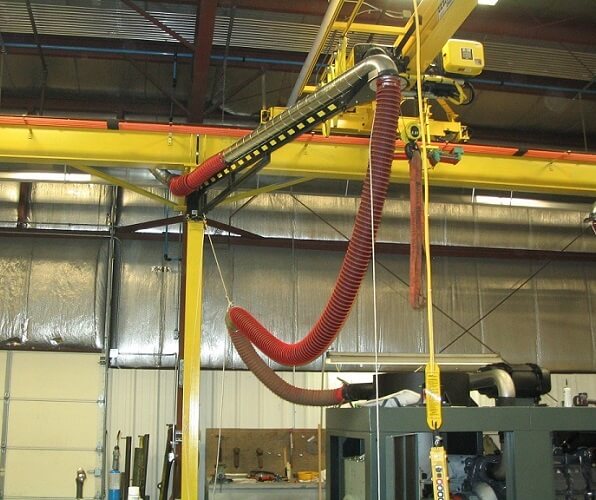 Boom arms shown installed in a tractor repair shop for diesel exhaust removal.