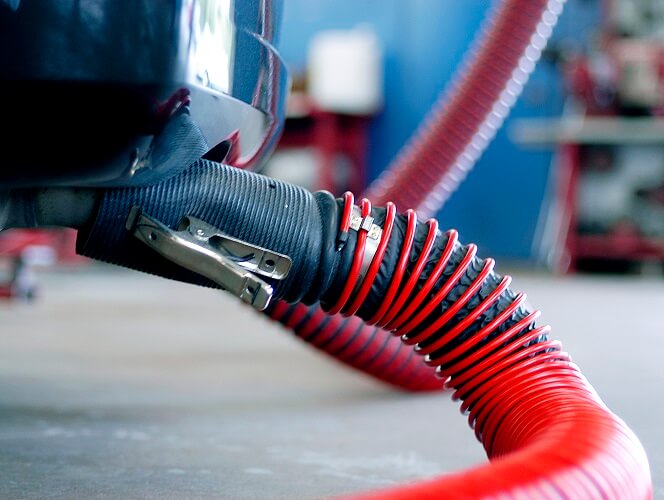 A tailpipe adapter attached to a passenger vehicle to exhaust gas emissions.