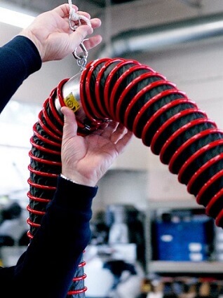 Fume-A-Vent overhead vehicle exhaust removal system being installed by technician.