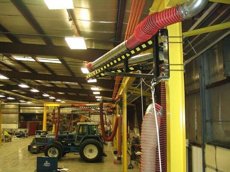 Wall-mounted boom arms with cable balancers lining the repair bays beneath the jib crane at Diesel Power Equipment Co.