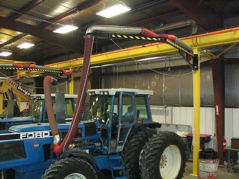 Articulating boom arm exhaust hose connected to a tractor at Diesel Power Equipment Co., working beneath the jib crane